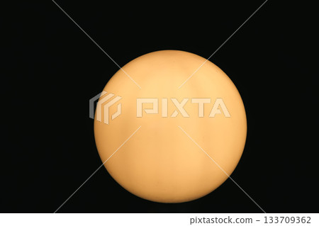 Glowing Yellow-Orange Sphere on Black Background with Subtle Texture 133709362