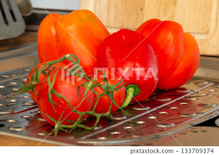 Fresh Bell Peppers and Tomatoes on Metal Surface with Water Droplets Fresh Bell Peppers and Tomatoes on Metal Surface with Water Droplets 133709374