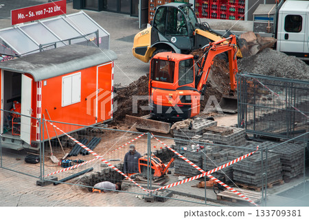 Urban Roadwork Scene with Excavator, Loader, and Construction Worker Urban Roadwork Scene with Excavator, Loader, and Construction Worker 133709381