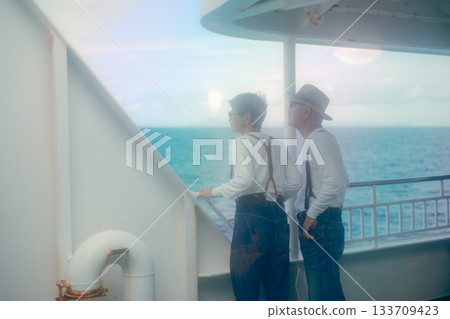 Travel scene of a senior couple looking at the scenery on the ferry deck Travel scene of a senior couple looking at the scenery on the ferry deck 133709423
