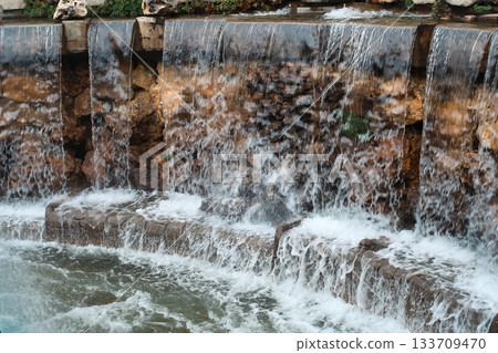 Cascading stone waterfall feature with flowing water Cascading stone waterfall feature with flowing water 133709470