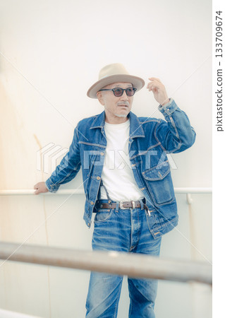 Portrait of a senior man wearing a denim jacket Portrait of a senior man wearing a denim jacket 133709674