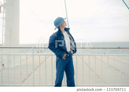 Portrait of a denim-style senior woman looking at the sea Portrait of a denim-style senior woman looking at the sea 133709711