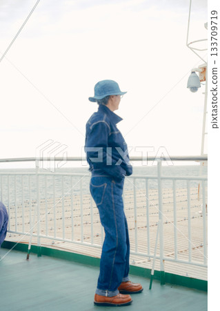 Portrait of a denim-style senior woman looking at the sea Portrait of a denim-style senior woman looking at the sea 133709719