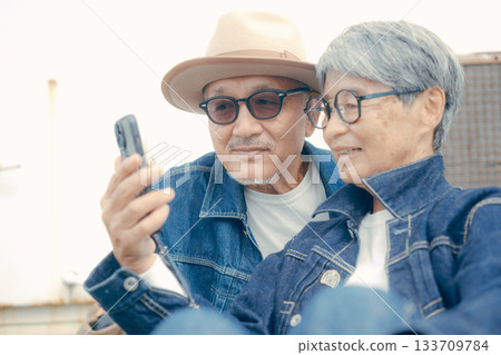 一對老年夫婦正在看智慧型手機的肖像 133709784