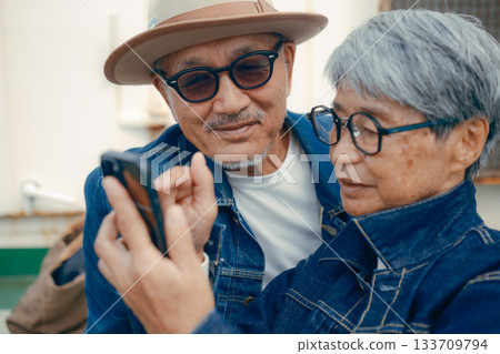 一對老年夫婦正在看智慧型手機的肖像 133709794