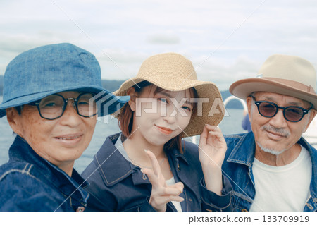 Portrait of three people taking a selfie on a ferry 133709919