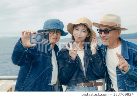 Portrait of three people taking a selfie on a ferry 133709924