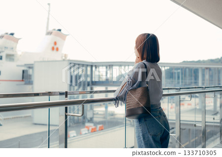 一位女子側臉望著碼頭的鏡頭。 一位女子側臉望著碼頭的鏡頭。 133710305