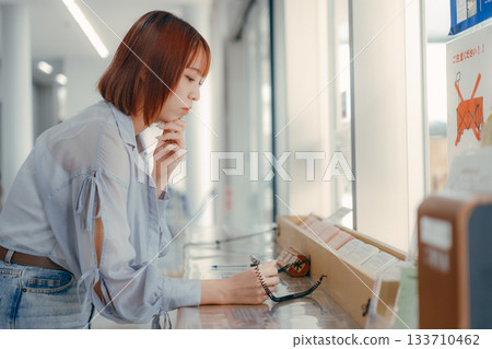 A woman filling out paperwork at the counter A woman filling out paperwork at the counter 133710462