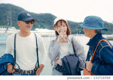 Portrait of three people standing side by side at the harbor 133710769