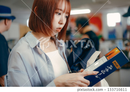 一位女士正在紀念品區挑選商品。 133710811