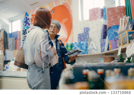 一位家長帶著孩子在店內挑選商品。 133710868