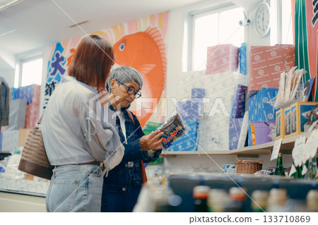 一位家長帶著孩子在店內挑選商品。 133710869