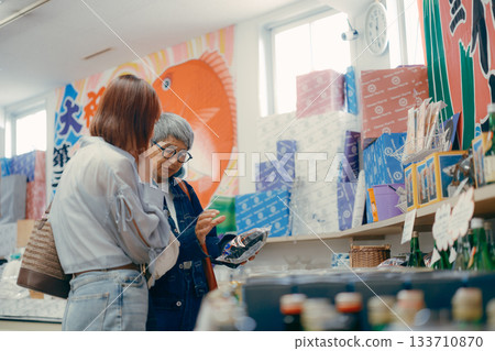 一位家長帶著孩子在店內挑選商品。 133710870