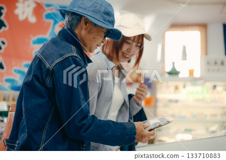 一位家長帶著孩子在店內挑選商品。 一位家長帶著孩子在店內挑選商品。 133710883