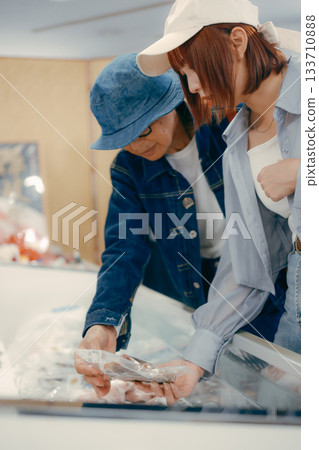 一位家長帶著孩子在店內挑選商品。 133710888