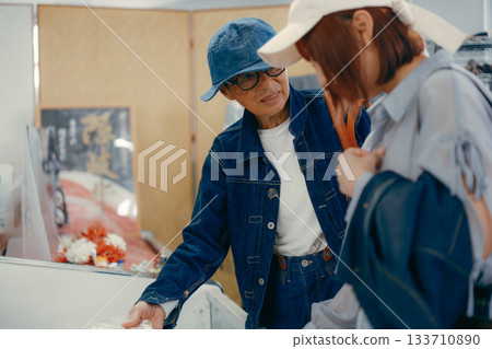 一位家長帶著孩子在店內挑選商品。 133710890