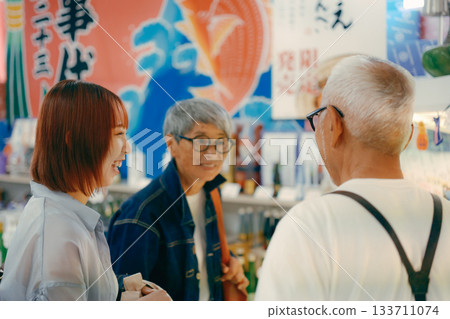 三個人在店內一邊看商品一邊聊天。 三個人在店內一邊看商品一邊聊天。 133711074