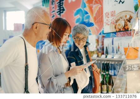 Three people talking while looking at products in the store Three people talking while looking at products in the store 133711076