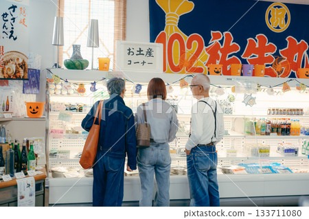 三個人在店內一邊看商品一邊聊天。 三個人在店內一邊看商品一邊聊天。 133711080