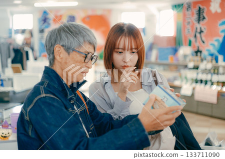 一位家長帶著孩子在店內挑選商品。 133711090