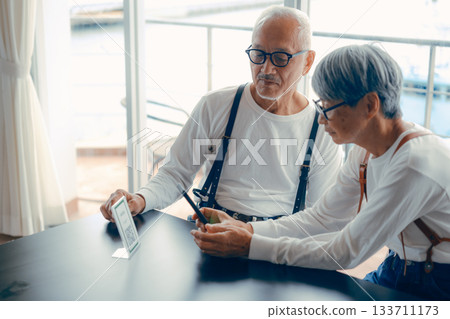 The two of them check the menu using the QR code. The two of them check the menu using the QR code. 133711173