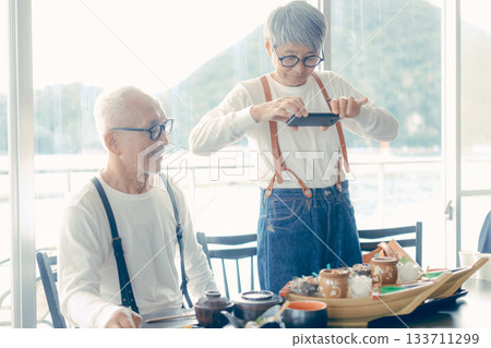 A moment before the meal, taking a photo of the boat-shaped platter with a smartphone 133711299