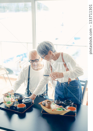 A moment before the meal, taking a photo of the boat-shaped platter with a smartphone 133711301