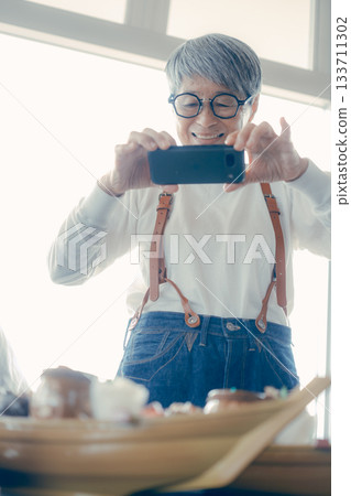 A moment before the meal, taking a photo of the boat-shaped platter with a smartphone A moment before the meal, taking a photo of the boat-shaped platter with a smartphone 133711302