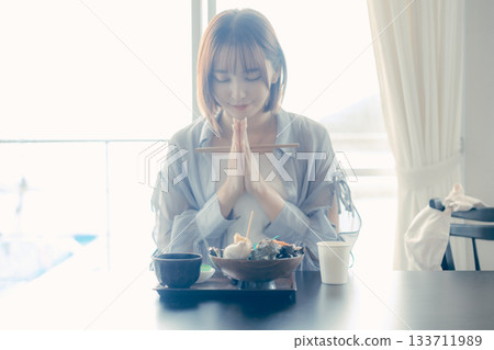 A scene before lunch of a woman in her twenties eating a seafood bowl A scene before lunch of a woman in her twenties eating a seafood bowl 133711989