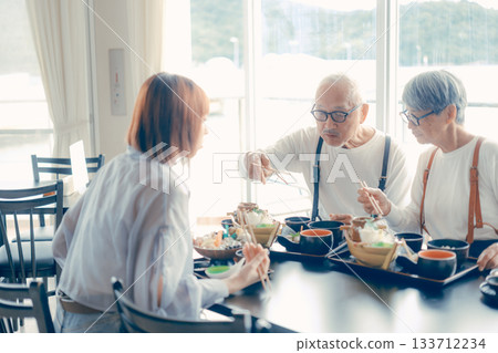 A meal scene of three parents and children enjoying seafood on a trip 133712234