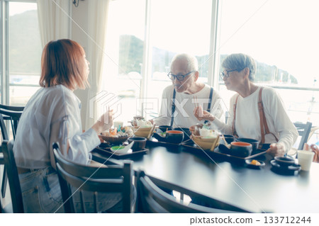 A meal scene of three parents and children enjoying seafood on a trip 133712244