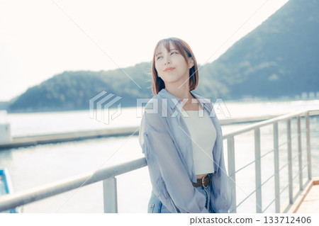 Portrait of a woman in her twenties smiling at the seaside Portrait of a woman in her twenties smiling at the seaside 133712406