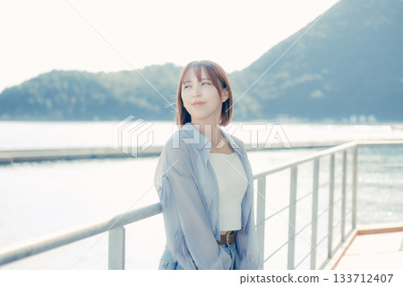 Portrait of a woman in her twenties smiling at the seaside Portrait of a woman in her twenties smiling at the seaside 133712407