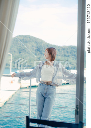 Portrait of a woman in her twenties smiling at the seaside 133712410