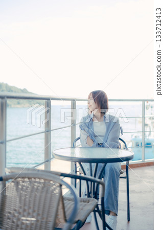 Portrait of a woman in her twenties smiling at the seaside Portrait of a woman in her twenties smiling at the seaside 133712413