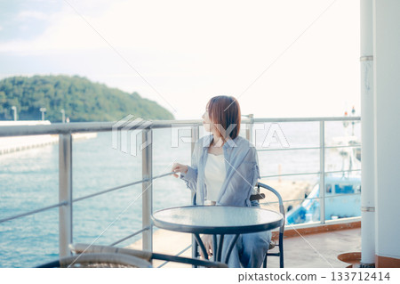 Portrait of a woman in her twenties smiling at the seaside Portrait of a woman in her twenties smiling at the seaside 133712414