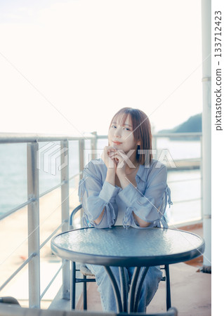 Portrait of a woman in her twenties smiling at the seaside Portrait of a woman in her twenties smiling at the seaside 133712423