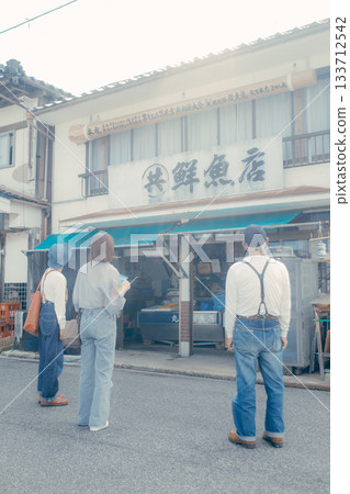 A scene of three parents and children strolling along the beach 133712542