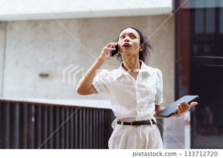 African black businesswoman walking on the street in city. African black businesswoman walking on the street in city. 133712720