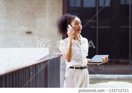 African black businesswoman walking on the street in city. African black businesswoman walking on the street in city. 133712721