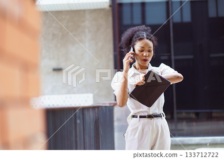 African black businesswoman walking on the street in city. 133712722
