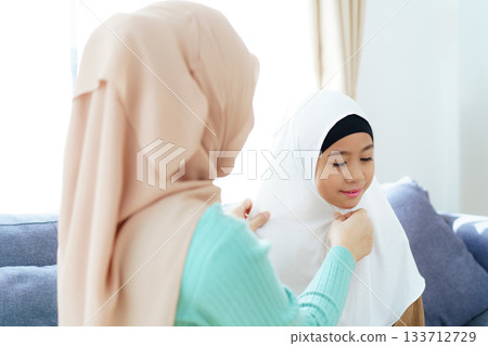 Asian muslim family's lifestyles concept. Woman get her daughter dressed. Asian muslim family's lifestyles concept. Woman get her daughter dressed. 133712729
