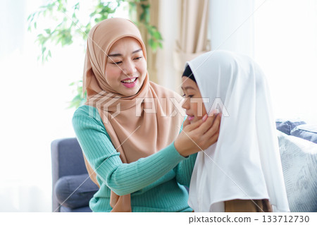 Asian muslim family's lifestyles concept. Woman get her daughter dressed. Asian muslim family's lifestyles concept. Woman get her daughter dressed. 133712730