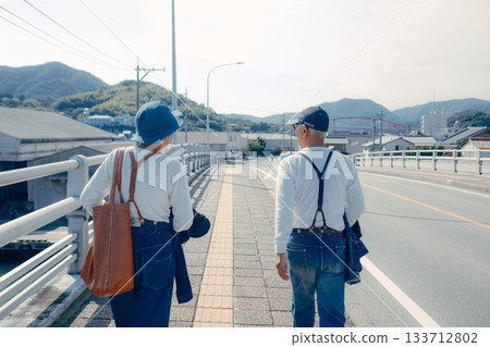 Travel scene of a senior couple in their 60s standing by the seaside Travel scene of a senior couple in their 60s standing by the seaside 133712802