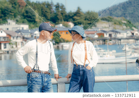 Travel scene of a senior couple in their 60s standing by the seaside Travel scene of a senior couple in their 60s standing by the seaside 133712911