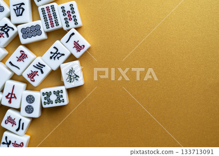 Mahjong tiles lined up on a golden background Mahjong tiles lined up on a golden background 133713091