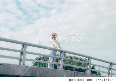 一位二十多歲的女子站在橋上仰望天空的肖像 一位二十多歲的女子站在橋上仰望天空的肖像 133713108