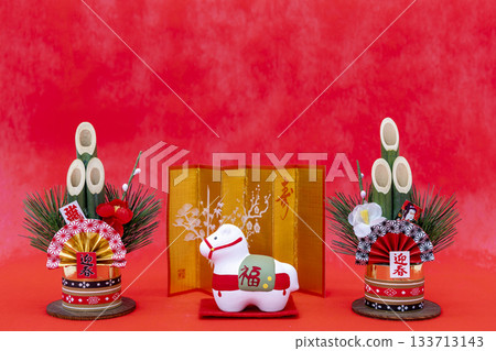 Horse zodiac ornaments and New Year's pine decorations placed on a bright red background Horse zodiac ornaments and New Year's pine decorations placed on a bright red background 133713143